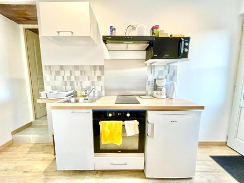 une cuisine avec des armoires blanches et un four dans l'établissement La Salamandre, Blois-Chaumont-Amboise-Zoo Beauval, à Coulanges