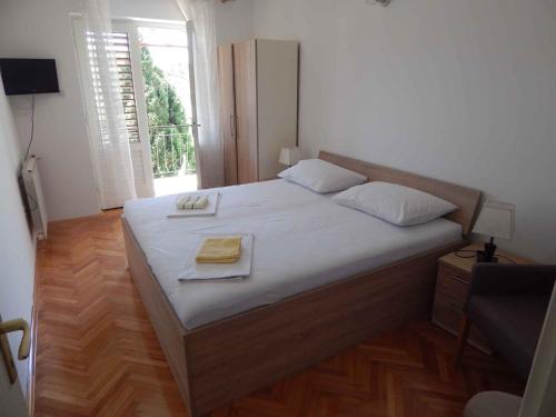 a bedroom with a large bed with white sheets and a window at Apartment Senj 1 in Senj