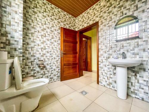 a bathroom with a toilet and a sink at MyPlace Suites in Kigali