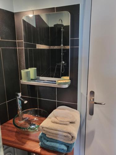 une salle de bain avec un lavabo, un miroir et des serviettes dans l'établissement Quai Babord, à Fécamp