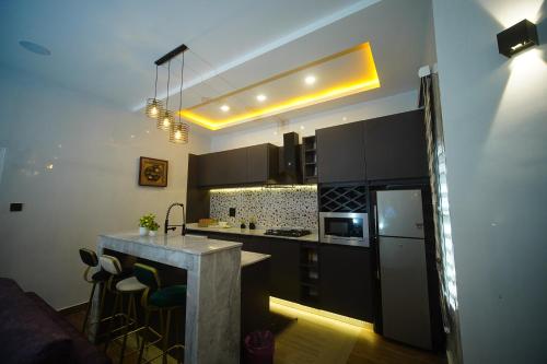 a kitchen with black cabinets and a counter top at Hortencia by Durudove Apartments in Kubwa