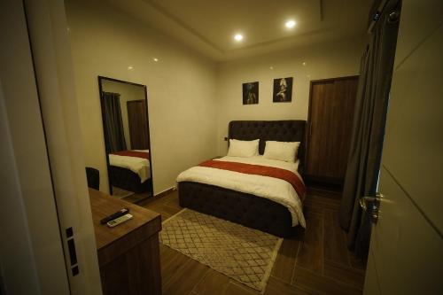 a small bedroom with a bed and a mirror at Hortencia by Durudove Apartments in Kubwa