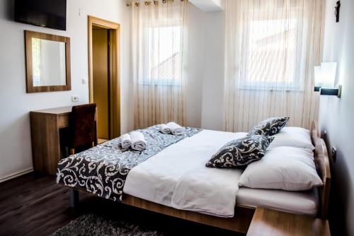 1 dormitorio con cama con almohadas y espejo en Hotel Villa Monako, en Međugorje