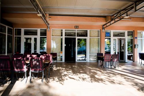 a conference room with tables and chairs and windows at Hotel Villa Monako in Međugorje
