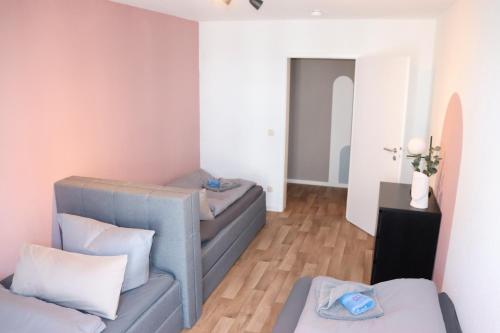 ein Wohnzimmer mit zwei grauen Sofas und einem Spiegel in der Unterkunft Studio - ONE / Netflix Balkon Wifi in Chemnitz