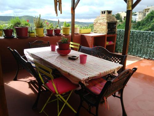 a table and chairs on a patio with potted plants at La Posadica Casa Aldabe in San Martín de Unx