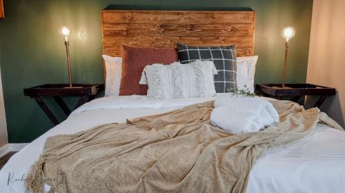 a bed with a blanket on it with two lamps at The Aloe in East London