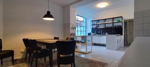 - une cuisine et une salle à manger avec une table et des chaises dans l'établissement Loft 46 - Long And Shortstay, à Berlin