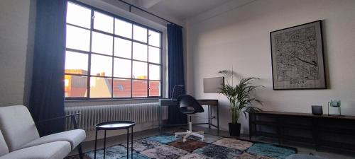 a living room with a couch and a window at Loft46 - Self Checkin - Long and Shortstay in Berlin