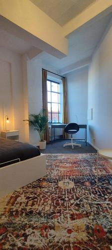 a room with a bed and a desk and a rug at Loft46 - Self Checkin - Long and Shortstay in Berlin