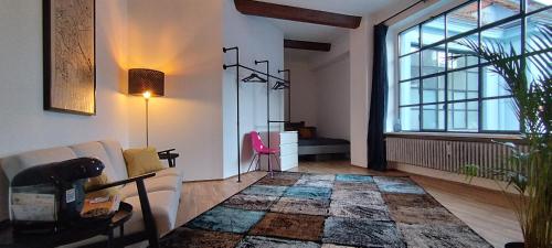 a living room with a couch and a large window at Loft46 - Self Checkin - Long and Shortstay in Berlin