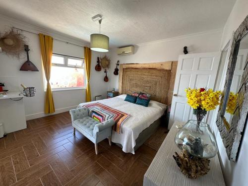 1 dormitorio con 1 cama y un jarrón de flores en Tenerife Sur Habitación de Lujo, en Adeje