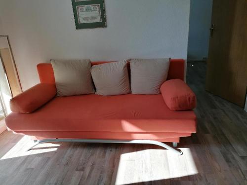 a red couch with two pillows sitting in a room at Mühlhausen Am Schadeberg in Mühlhausen