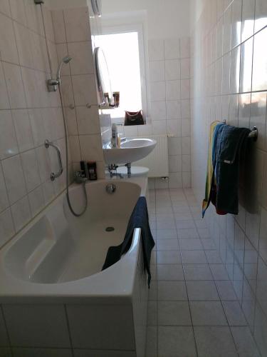 a white bathroom with a tub and a sink at Mühlhausen Am Schadeberg in Mühlhausen