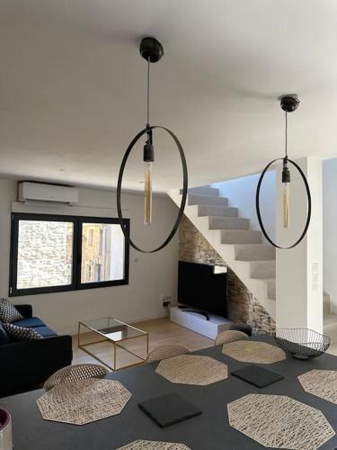 un salon avec trois lustres et un escalier dans l'établissement Charmante maison en pierre-TAVEL, à Tavel