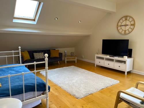 a bedroom with a bed and a flat screen tv at City Link - Mapperley Park Penthouse - Free parking,tram&bus,HSwifi,7ppl by KP in Nottingham