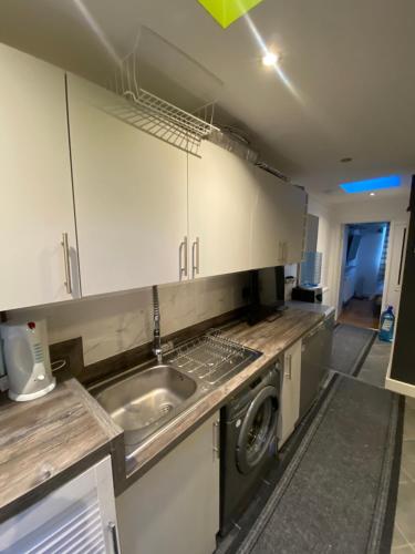 a kitchen with a sink and a washing machine at South London Private Guest Studio in Sydenham