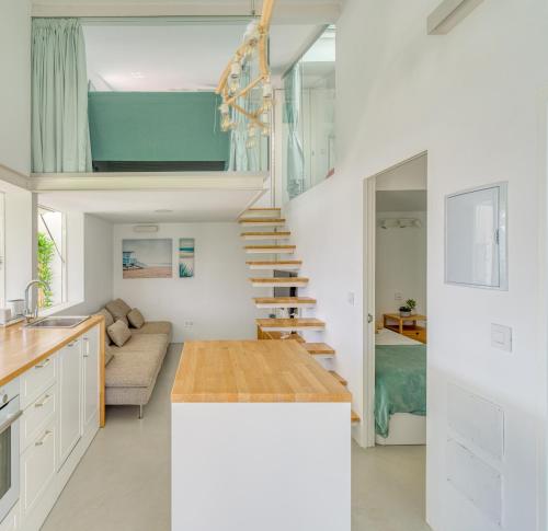 uma cozinha e sala de estar com uma escada numa casa em Aquarium Bungalow private jacuzzi, 3 bedrooms, AC and Bikes em Maspalomas