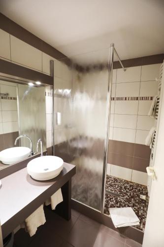 a bathroom with two sinks and a shower at Logis Le Bourguignon in Bèze