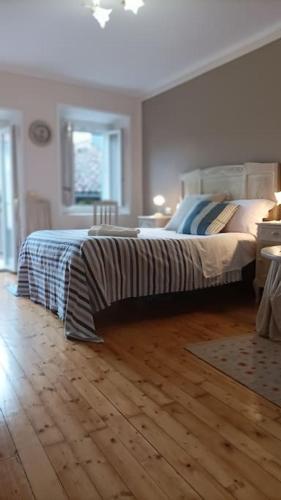 a bedroom with a bed and a wooden floor at Quick Home - Casetta Blu in Gaglianico