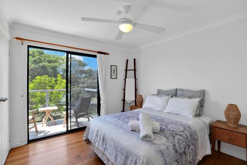 a bedroom with a bed and a sliding glass door at Quarterdeck in Point Lookout