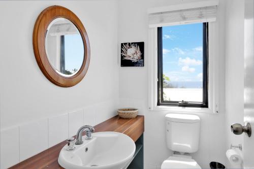 a bathroom with a sink and a mirror and a toilet at Quarterdeck in Point Lookout