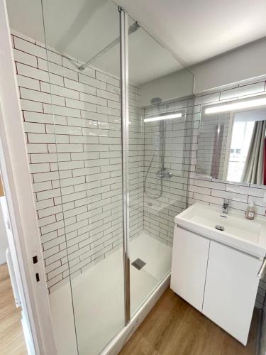 a bathroom with a glass shower and a sink at Appartement chaleureux en centre-ville de Caen in Caen