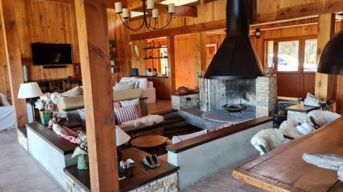 sala de estar con sofá y chimenea en Casa de Montaña Valle Escondido en San Martín de los Andes
