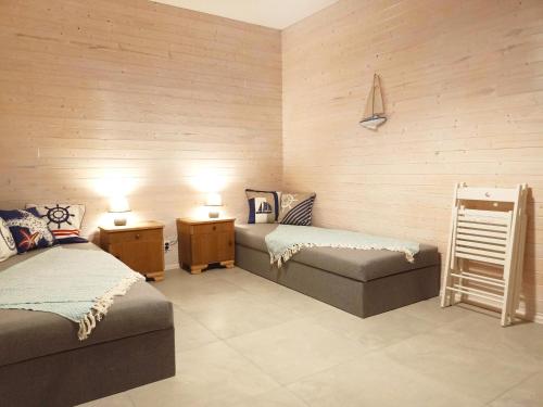 a room with two beds and a bench and lamps at Rybacki Domek 50 metrów do morza! in Dziwnów