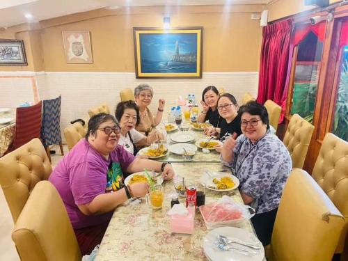 a group of women sitting at a table eating food at Miracle Gallery Hotel in Makkasan