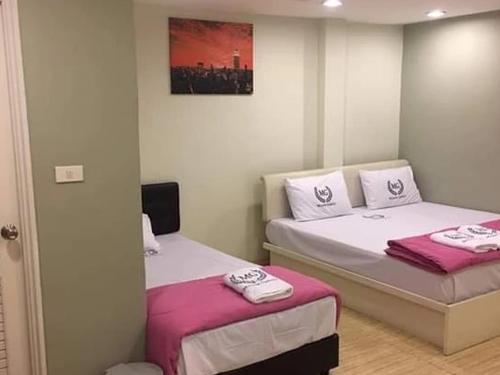 Makkasan的住宿－Miracle Gallery Hotel，配有粉红色和白色床单的客房内的两张床