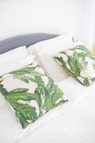 a bed with two green pillows on it at Retropolitan Living Patras in Patra