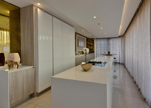una cocina con una isla blanca en una habitación en The Houghton Hotel, Spa, Wellness & Golf, en Johannesburgo