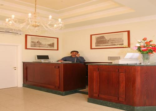 a man talking on a phone at a reception desk at Hotel Chicago in Rome