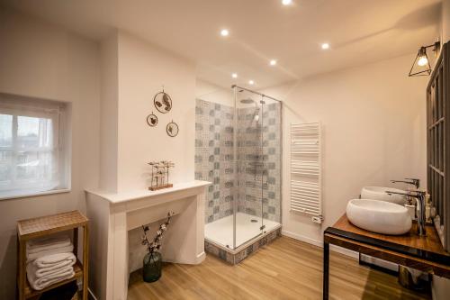 uma casa de banho com uma cabina de duche em vidro e um lavatório. em Villa Valentine em Veules-les-Roses
