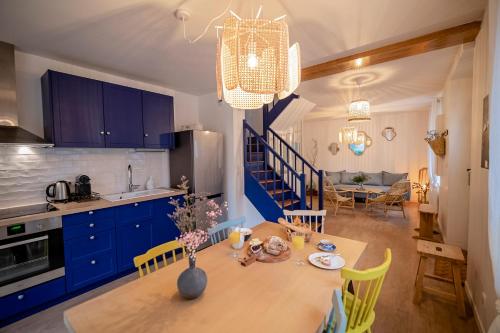 une cuisine et une salle à manger avec une table et des armoires bleues dans l'établissement Villa Valentine, à Veules-les-Roses