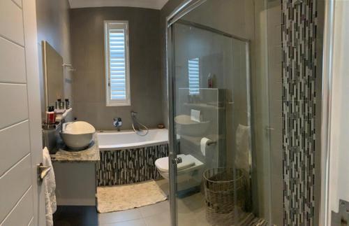 a bathroom with a shower and a toilet and a sink at Seadrive in Walvis Bay