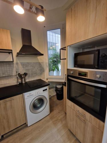 une cuisine avec un lave-linge et un micro-ondes dans l'établissement Rivoli SeaSide Apartment, à Nice