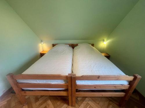 a bed in a green room with two pillows on it at Relaxing Villa with Pool in Filot