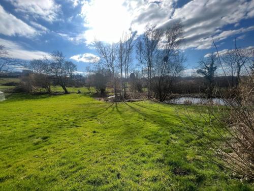 a grassy field with trees and a river at Relaxing Villa with Pool in Filot
