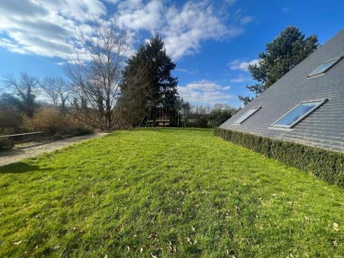 a large grassy yard next to a house at Relaxing Villa with Pool in Filot