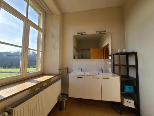 La salle de bains est pourvue d'un lavabo et d'une grande fenêtre. dans l'établissement Family-friendly accommodation in the forges of Orval opposite the abbey, à Abbaye Notre-Dame dʼOrval