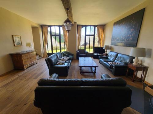 a living room with leather couches and a table at Accommodation in the forges of Orval in Abbaye dʼOrval