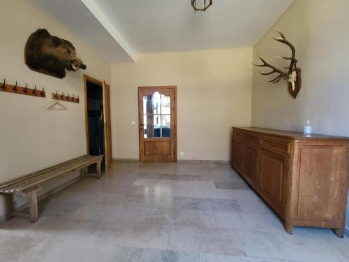 a living room with a bench and a deer head on the wall at Accommodation in the forges of Orval in Abbaye dʼOrval