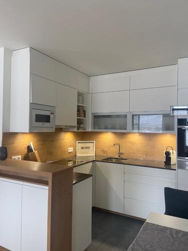 a kitchen with white cabinets and a counter top at Lake View Apartment Seecorso in Velden am Wörthersee