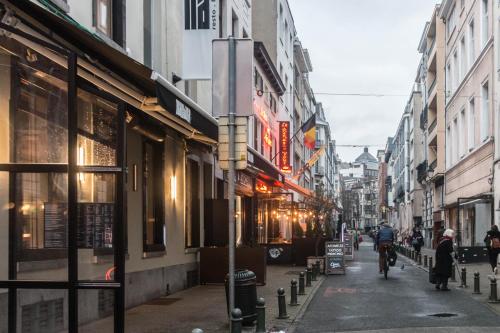 a city street with people walking down the street at QUARTIER LOUISE STUDIOS in Brussels