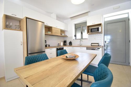 a kitchen with a wooden table and blue chairs at Kallixeni Villas in Rethymno Town