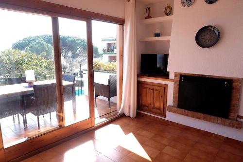 a living room with a large sliding glass door with a balcony at Apartamento con piscina L' Áncora in Calella de Palafrugell