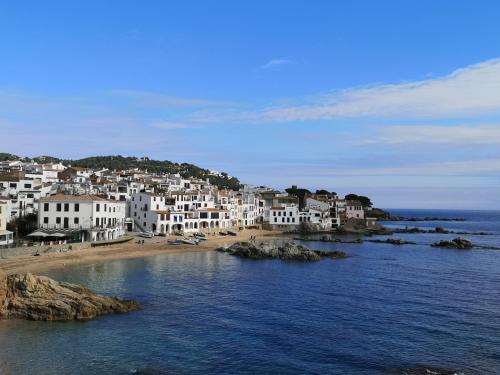 a view of a beach with white houses and the ocean at Apartamento con piscina L' Áncora in Calella de Palafrugell