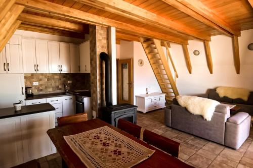 eine Küche und ein Wohnzimmer mit einem Sofa und einem Herd in der Unterkunft HILL VIEW Chalets in Žabljak